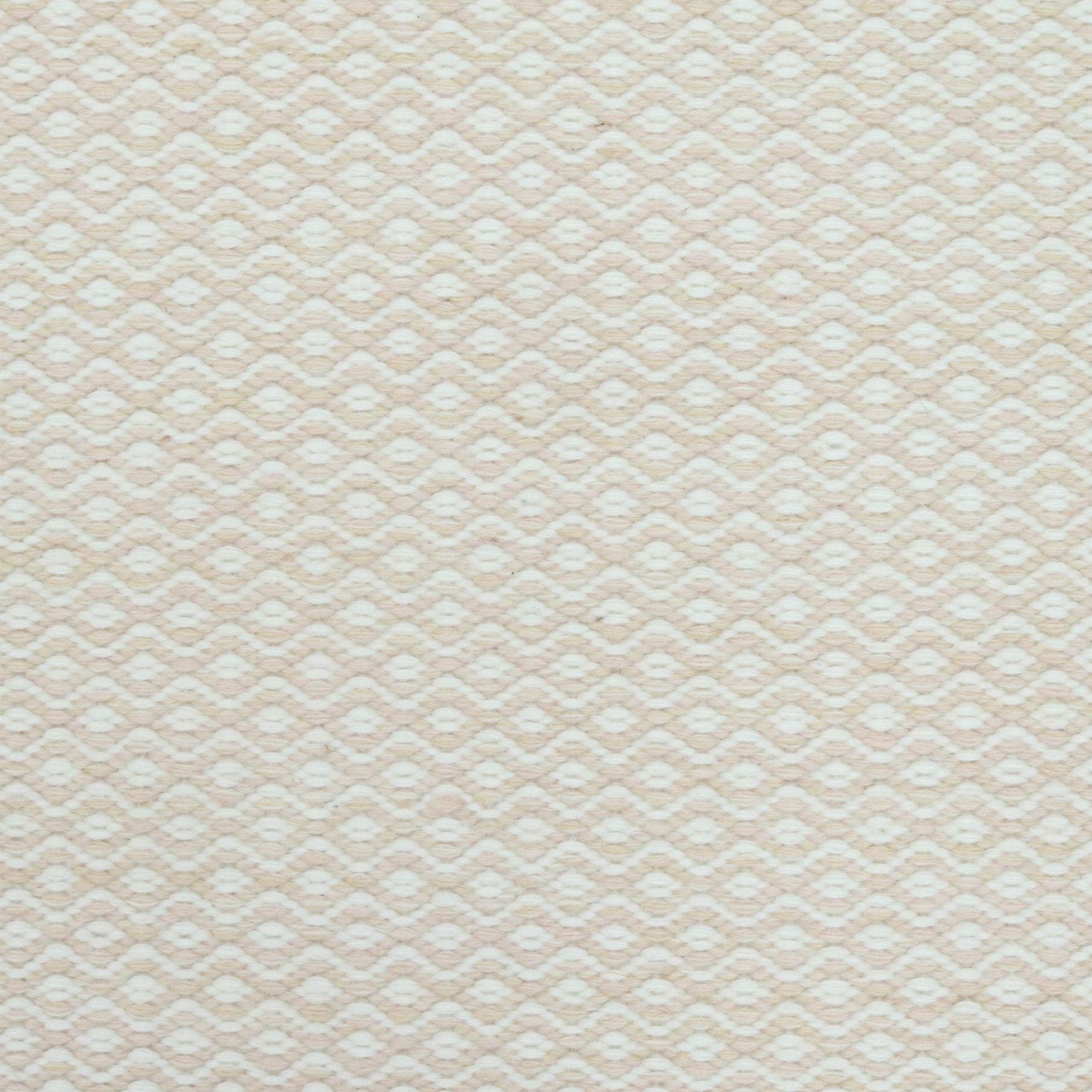 Flatweave rug in a small scale zigzag dot stripe in cream on a pale beige field.