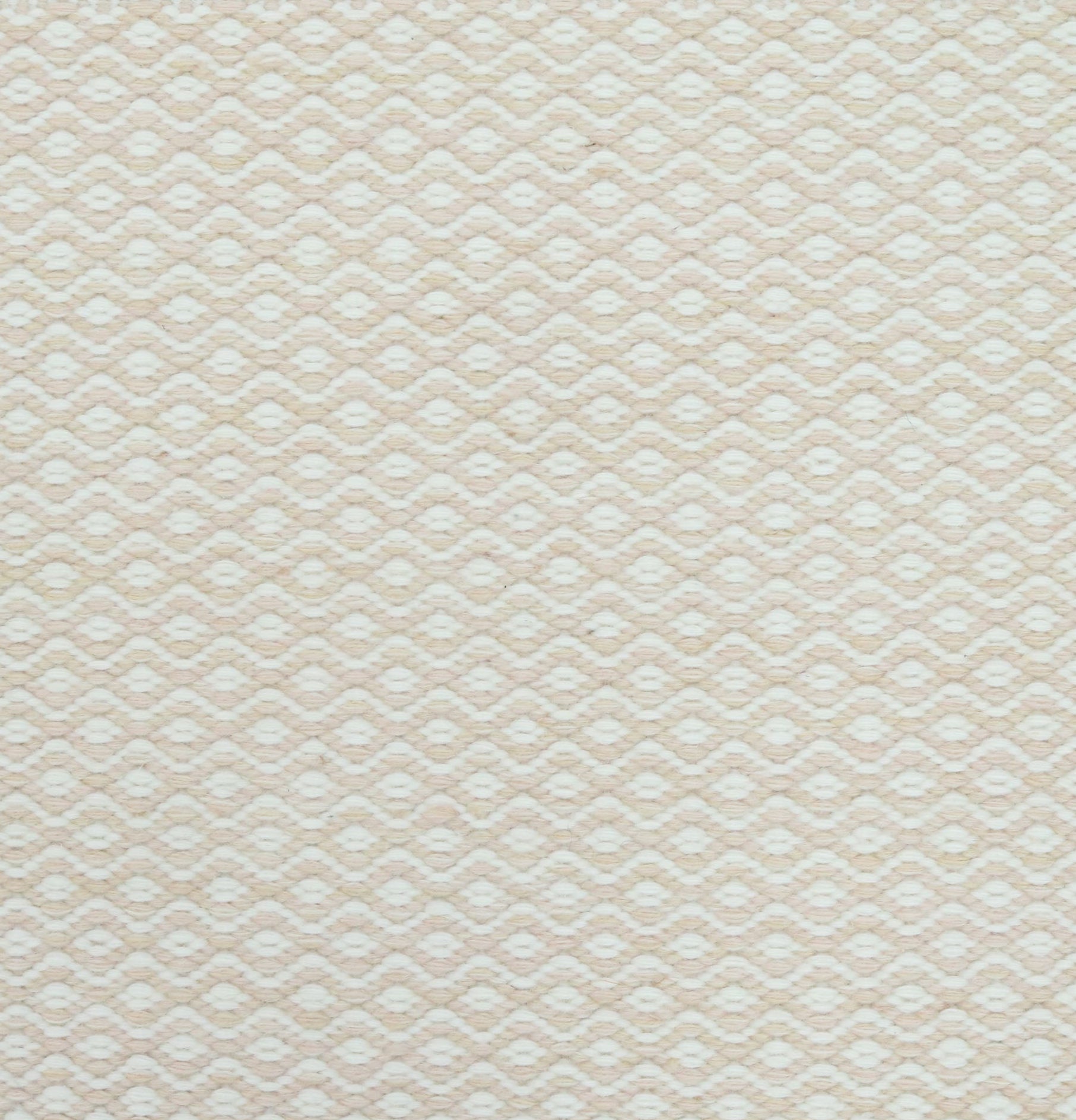 Flatweave rug in a small scale zigzag dot stripe in cream on a pale beige field.