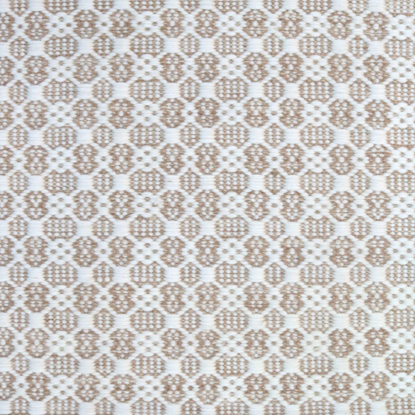 Flatweave rug in a small scale decorative lattice design in cream on a tan field. 