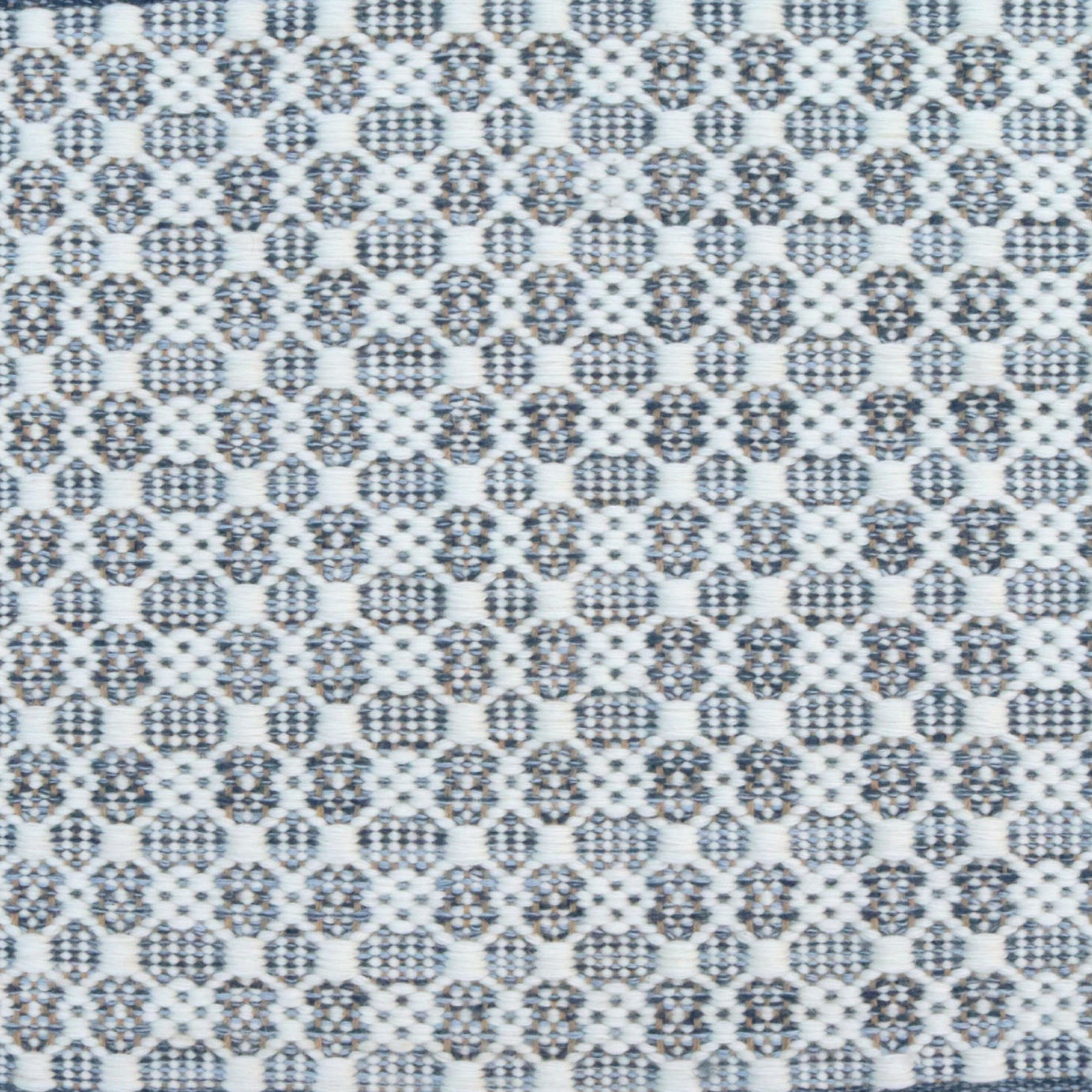 Flatweave rug in a small scale decorative lattice design in cream on a chambray blue field.