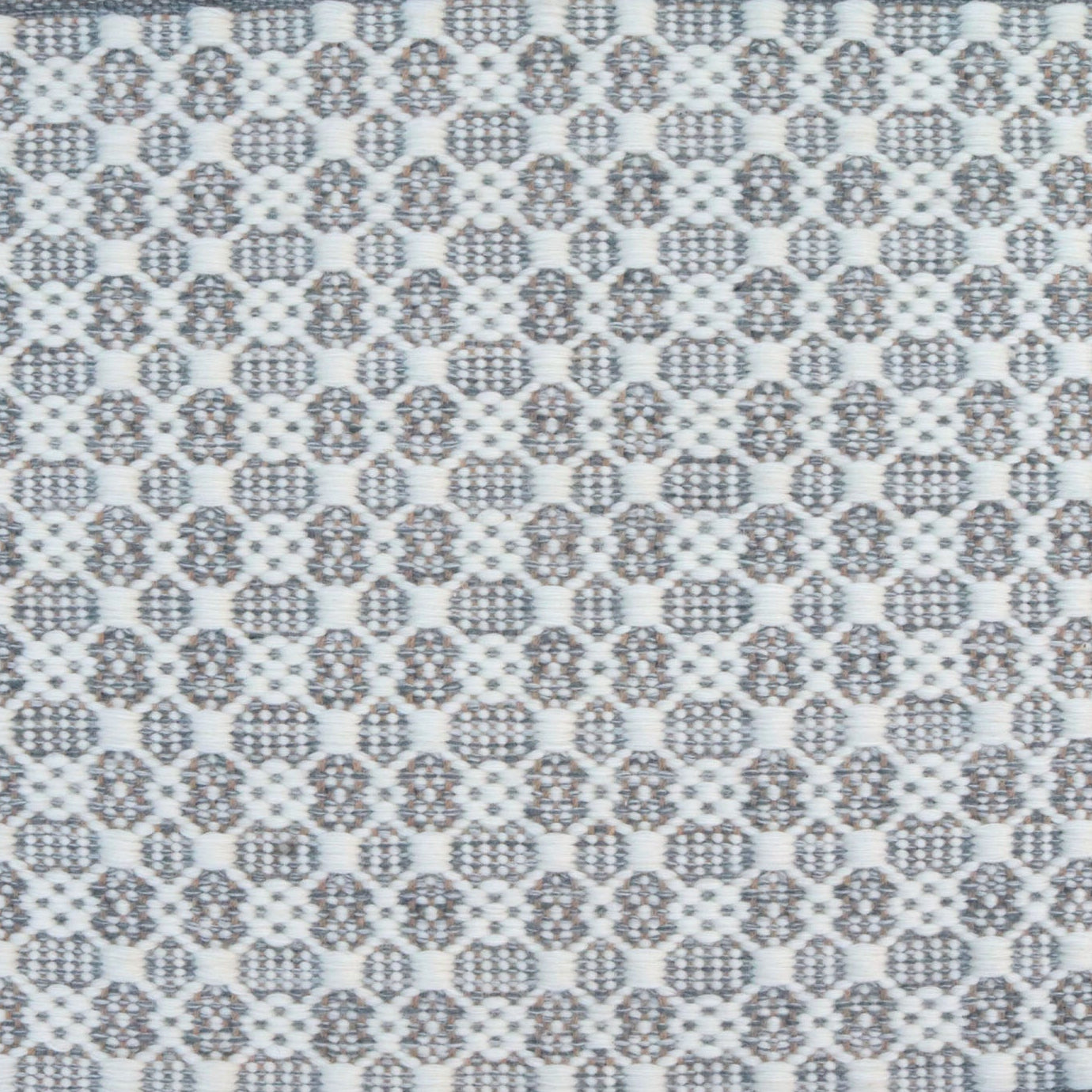 Flatweave rug in a small scale decorative lattice design in cream on a cool grey field. 