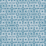 Detail of fabric in a gridded damask print in white on a blue field.