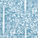 Detail of wallpaper in a large-scale tree and leaf print in white on a light blue field.