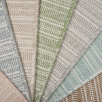 Stack of broadloom carpets in a textural stripe in a range of colors. 