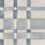 Detail of wallpaper in a large-scale checked pattern in shades of steel blue and pale grey.