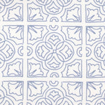 Detail of fabric in a damask lattice print in blue on a white field.
