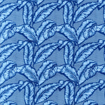 Detail of fabric in a dense leaf print in navy and blue on a blue field.
