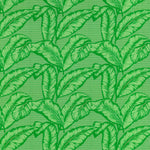 Detail of fabric in a dense leaf print in shades of green on a green field.