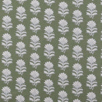 Detail of fabric in a repeating thistle print in white and blue on a green field.