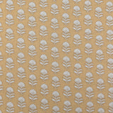 Detail of fabric in a repeating thistle print in cream and rust on an orange field.