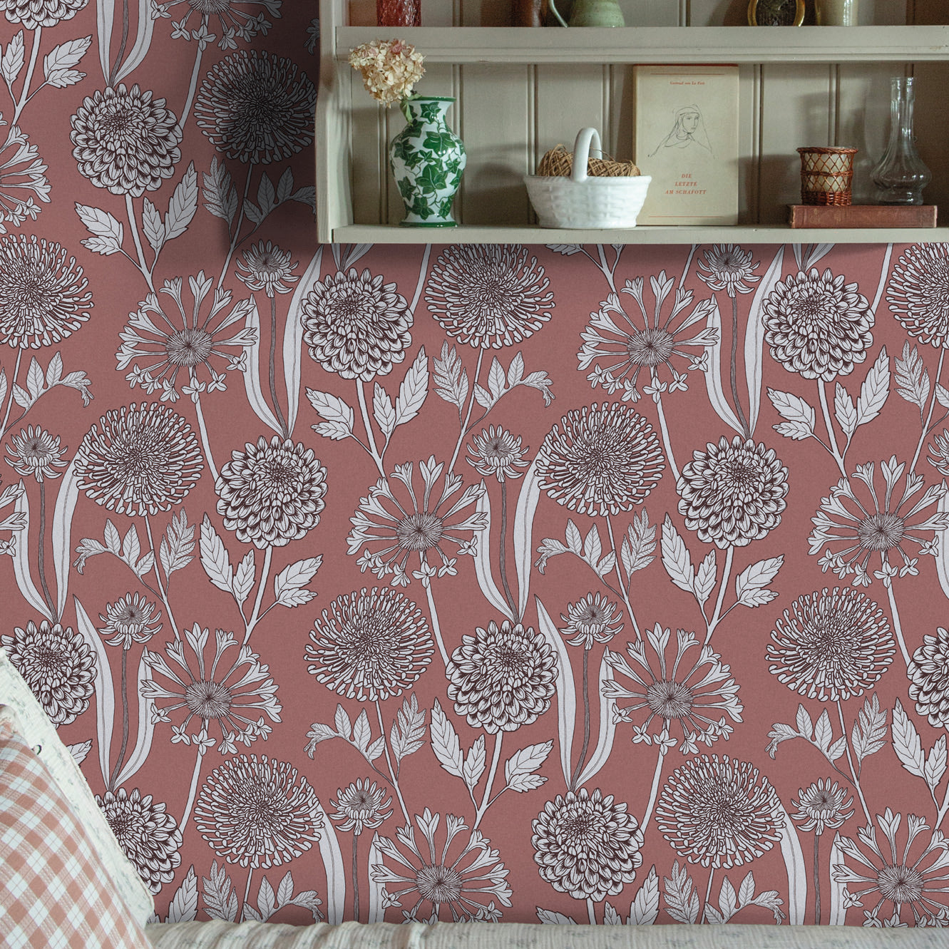 Cozy reading nook with a decorative wooden shelf against a pink floral wallpaper. 