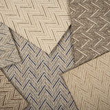 Stack of broadloom carpet samples in a herringbone pattern in array of neutral colors.