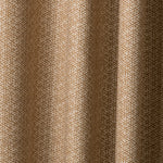 Draped printed fabric in a detailed geometric pattern in cream on a camel field.