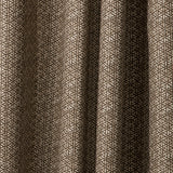 Draped printed fabric in a detailed geometric pattern in white on a dark brown field.