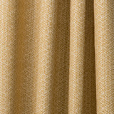 Draped printed fabric in a detailed geometric pattern in white on a goldenrod field.