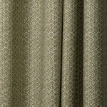 Draped printed fabric in a detailed geometric pattern in white on an olive field.