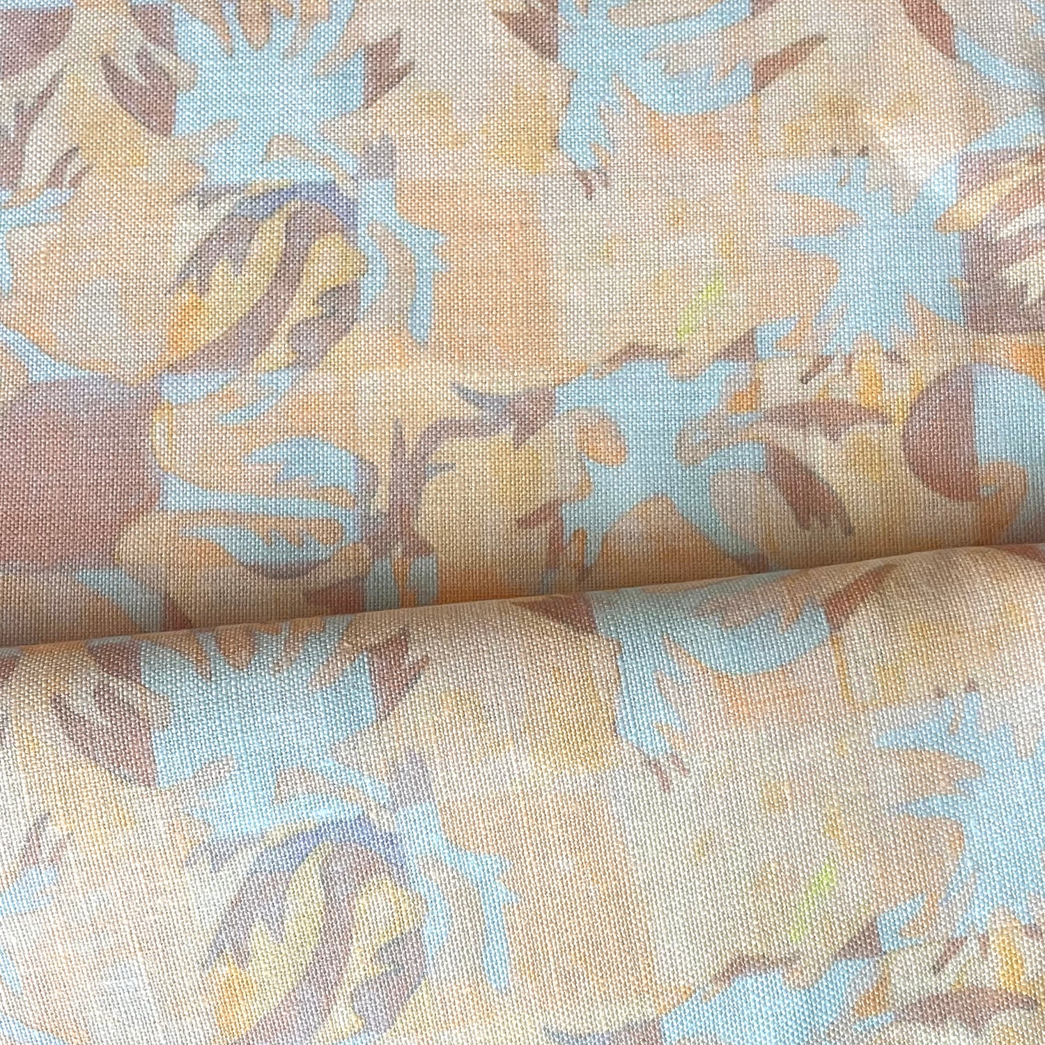 Draped fabric in painterly tropical checkerboard design in yellow, tan and blue. 