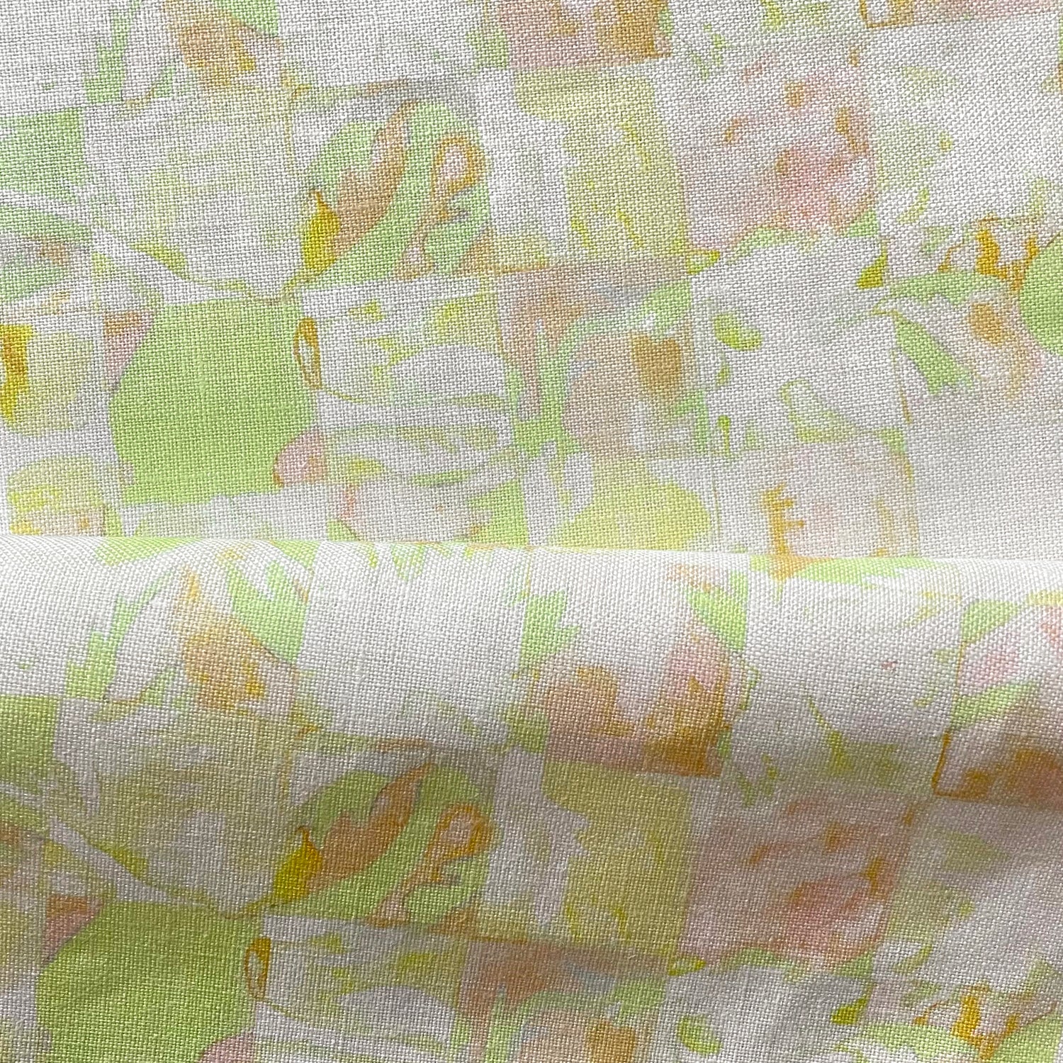 Draped fabric in painterly tropical checkerboard design in lime green, yellow and orange. 