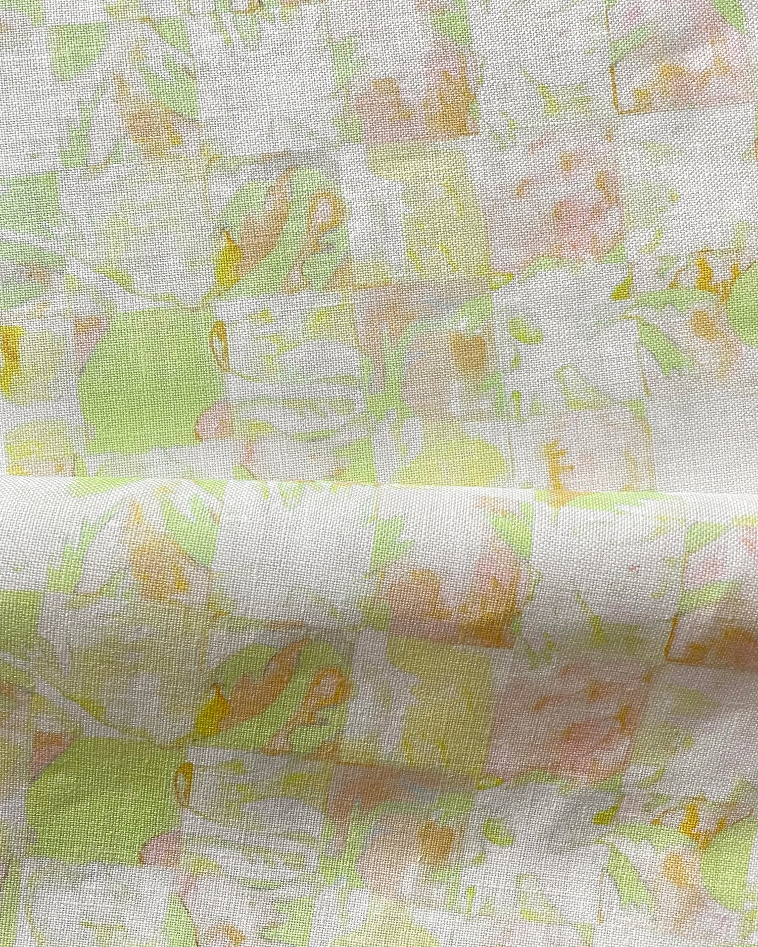 Draped fabric in painterly tropical checkerboard design in lime green, yellow and orange. 