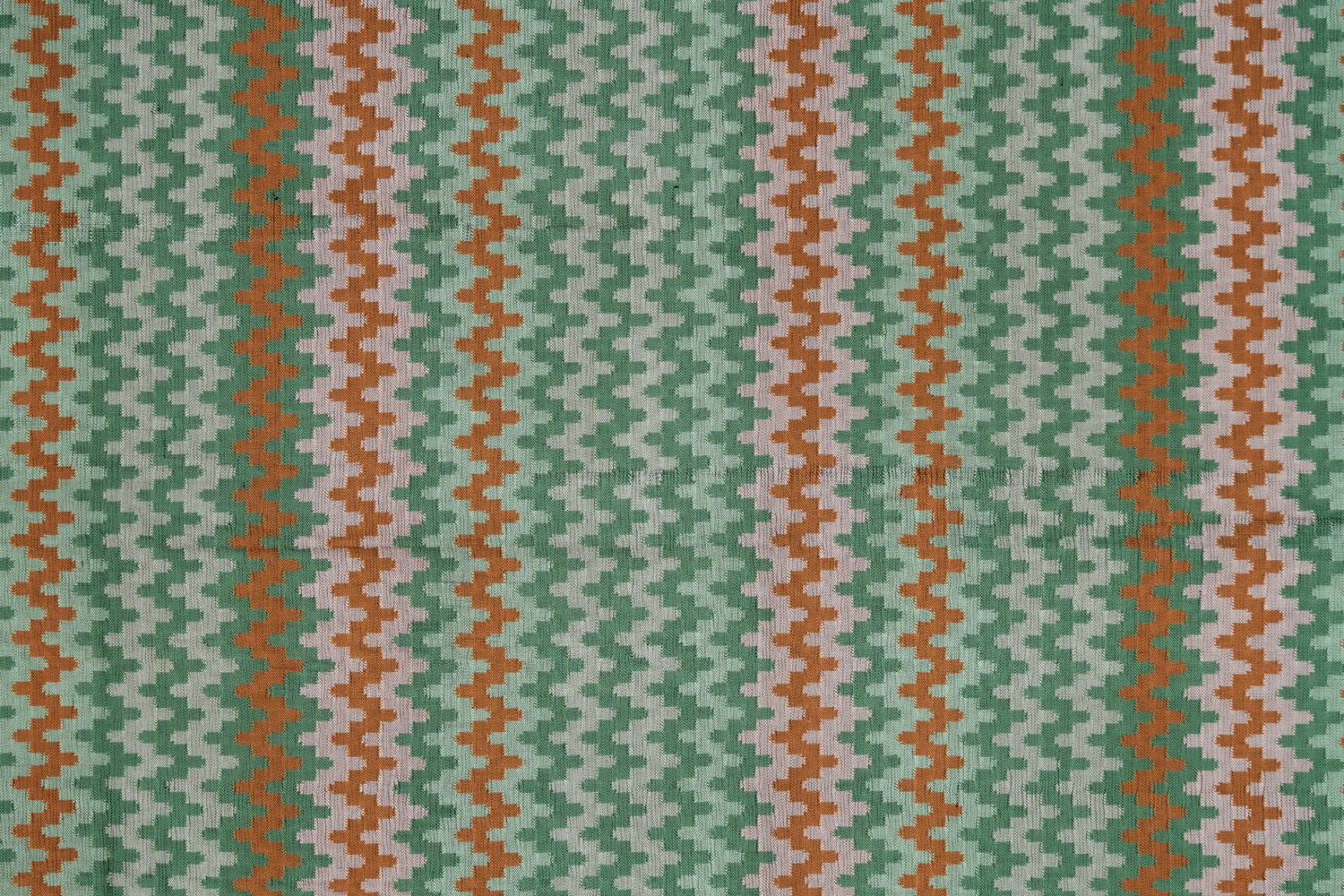 Handwoven silk fabric with zigzag design in green, orange, and beige.
