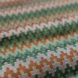Close-up of fabric with green, pink and orange striped zig pattern