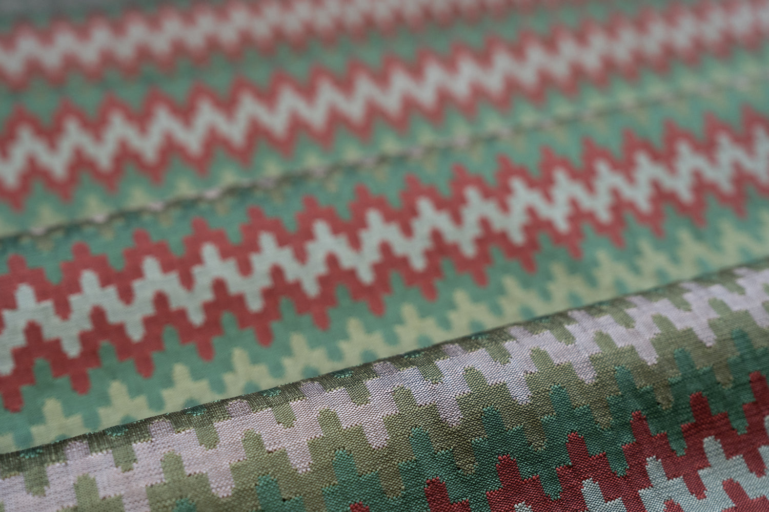 Close-up of fabric with a zigzag pattern in red, green, and white.