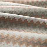 Close up of folded handwoven silk fabric with zigzag stripes in neutral colors. 