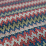 Close-up of fabric with zigzag and houndstooth patterns in red, blue, and green.
