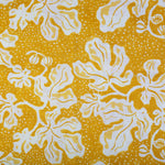 Detail of fabric in a playful botanical print in yellow and white on a bright yellow field.
