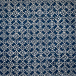 Detail of fabric in a repeating geometric print in cream on a navy field.