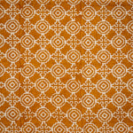 Detail of fabric in a repeating geometric print in cream on an ochre field.