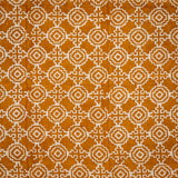 Detail of fabric in a repeating geometric print in cream on an ochre field.