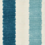 Detail of fabric in an ikat stripe print in shades of blue on a cream field.
