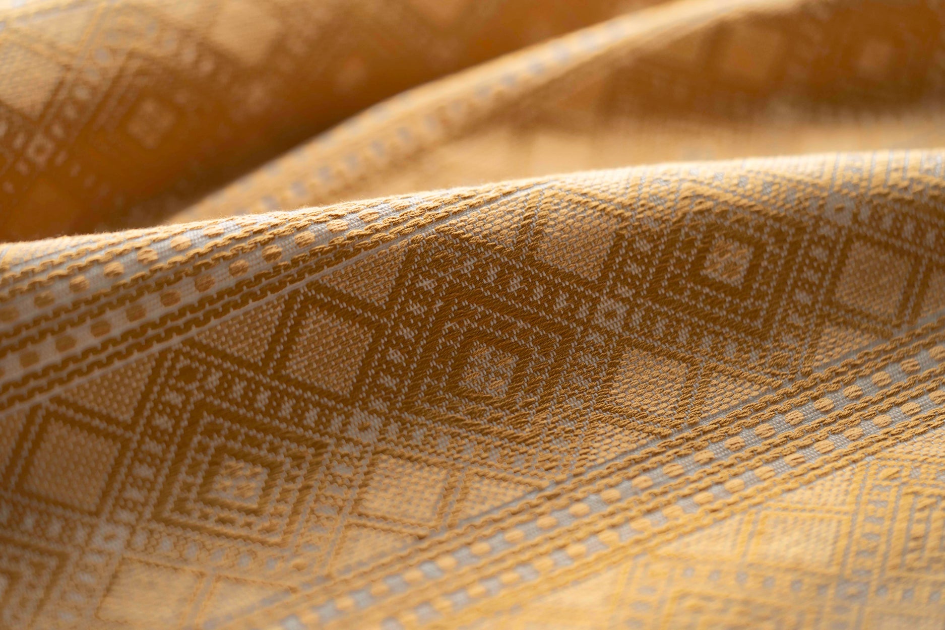 Close-up of textured fabric with geometric pattern in yellow