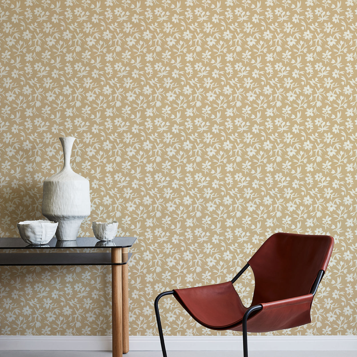 Modern chair and table against a white and tan floral wallpapered wall.