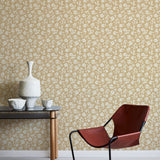 Modern chair and table against a white and tan floral wallpapered wall.