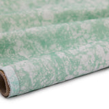 Partially unrolled fabric in an organic crumpled texture in light green on a cream field.