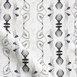 Detail of draped fabric yardage in a watercolor ikat stripe print in shades of gray and black on a white field.
