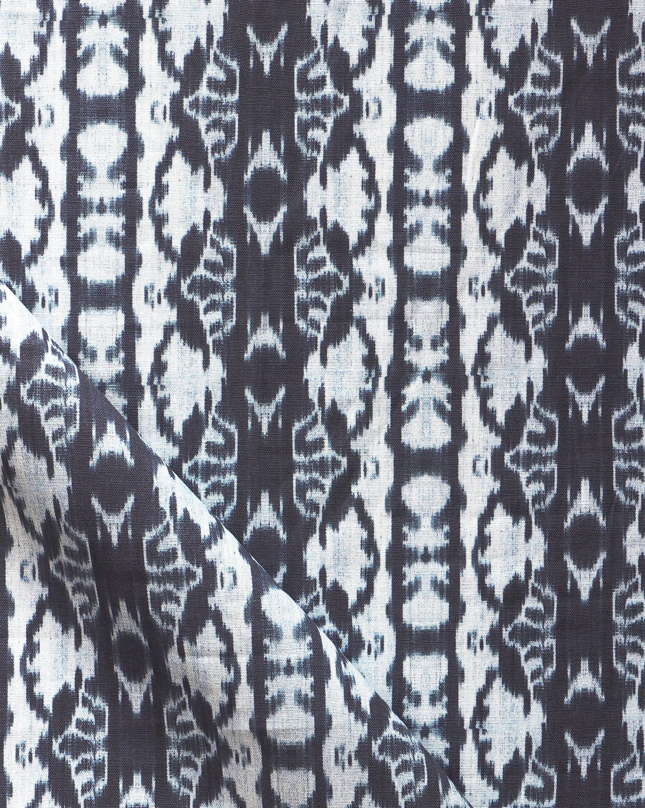 Detail of draped fabric yardage in a watercolor ikat stripe print in shades of white and blue on a gray field.