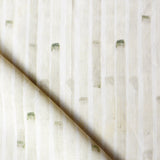 Detail of draped fabric in a painterly stripe print in tan on a white field.