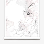 Partially unrolled wallpaper yardage in a painterly floral print in shades of pink and charcoal on a white field.