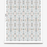 Partially unrolled wallpaper yardage in a painterly ikat print in turquoise, gray and tan.