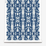 Partially unrolled wallpaper yardage in a painterly ikat print in blue and white.