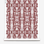 Partially unrolled wallpaper yardage in a painterly ikat print in rust and white.