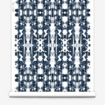 Partially unrolled wallpaper yardage in a painterly ikat print in navy and white.