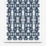 Partially unrolled wallpaper yardage in a painterly ikat print in navy and white.