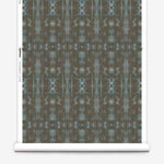 Partially unrolled wallpaper yardage in a painterly ikat print in turquoise and brown.