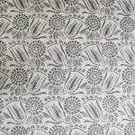 Detail of fabric in a dense floral print in gray on a white field.