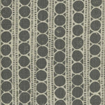 Detail of fabric in a circle and stripe print in cream on a gray field.