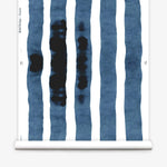 Wallpaper roll with bold watercolor stripes in inky blue and white on a white background.